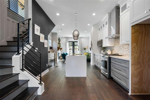 2328 Mason Dr, Atlanta, GA 30316 - kitchen featuring wall chimney exhaust hood, light countertops, appliances with stainless steel finishes, dark wood-style floors, and backsplash