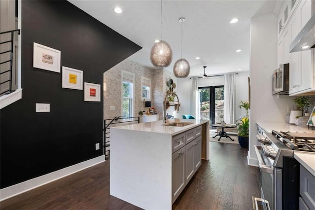 2328 Mason Dr, Atlanta, GA 30316 - kitchen featuring wall chimney exhaust hood, a sink, dark wood finished floors, a center island with sink, and stainless steel appliances