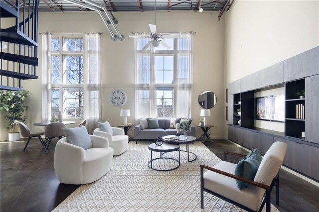 living room featuring ceiling fan, concrete floors, and a towering ceiling