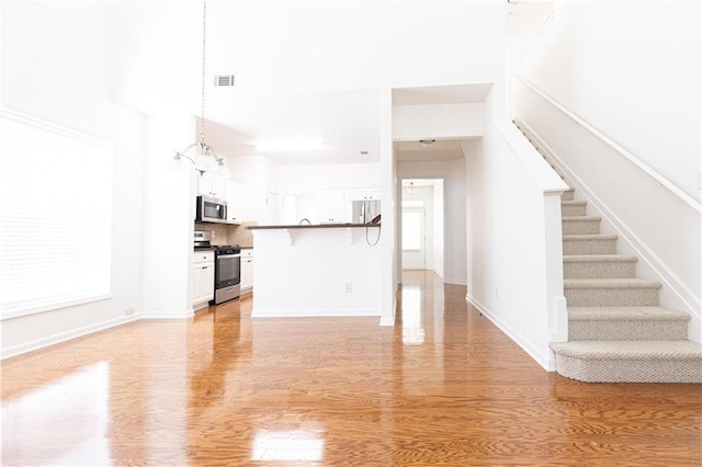 3277 Wyesham Cir, Duluth, GA 30096 - unfurnished living room featuring light wood-type flooring, stairs, and baseboards