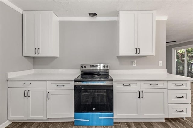 kitchen featuring dark wood-type flooring, white cabinets, electric range, ornamental molding, and a textured ceiling