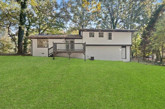 rear view of property featuring a lawn and a deck