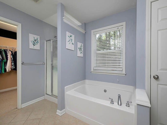 1535 Justine Way SE, Mableton, GA 30126 - bathroom featuring a shower stall, a bath, tile patterned flooring, a walk in closet, and baseboards