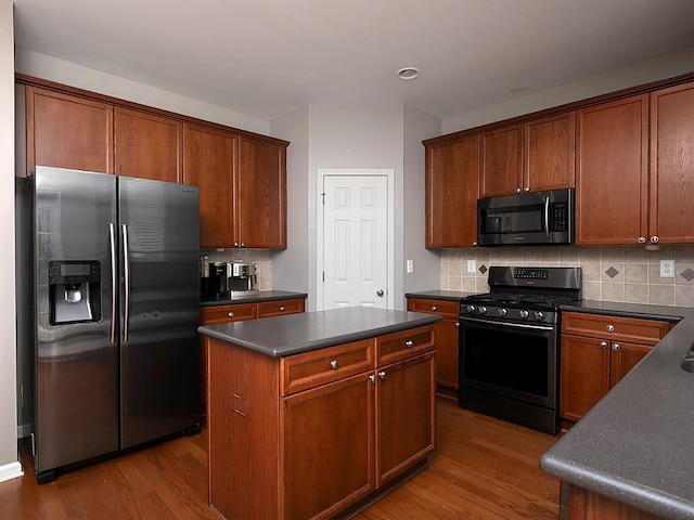 1535 Justine Way SE, Mableton, GA 30126 - kitchen with stainless steel appliances, dark countertops, wood finished floors, and decorative backsplash