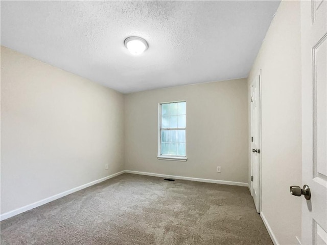 unfurnished room featuring a textured ceiling and carpet