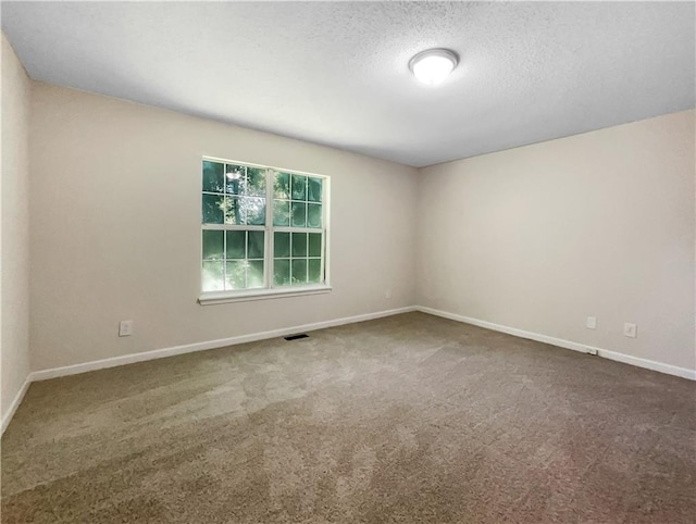 carpeted empty room with a textured ceiling