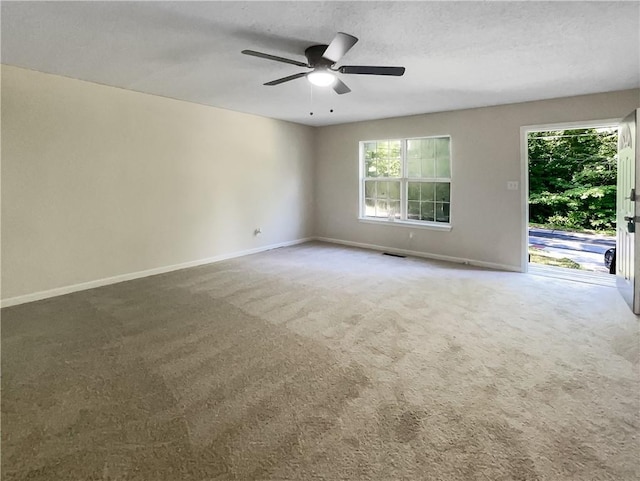 carpeted empty room with ceiling fan and a textured ceiling