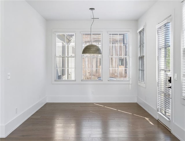 unfurnished dining area featuring dark hardwood / wood-style floors and a healthy amount of sunlight