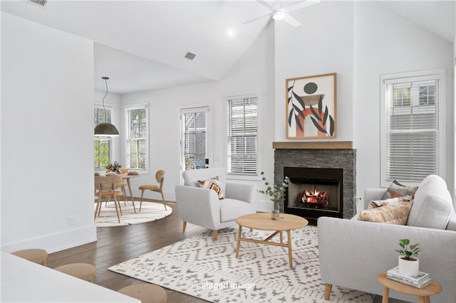 living room featuring hardwood / wood-style flooring, ceiling fan, a fireplace, and high vaulted ceiling