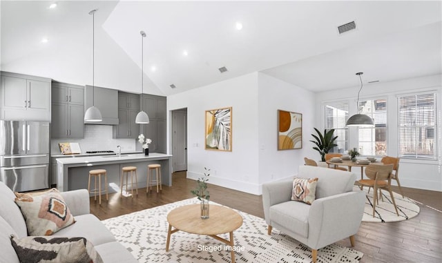 living room featuring high vaulted ceiling and dark wood-type flooring