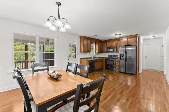 dining area with a notable chandelier and light hardwood / wood-style floors