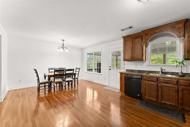 kitchen featuring pendant lighting, dishwasher, sink, plenty of natural light, and light hardwood / wood-style flooring