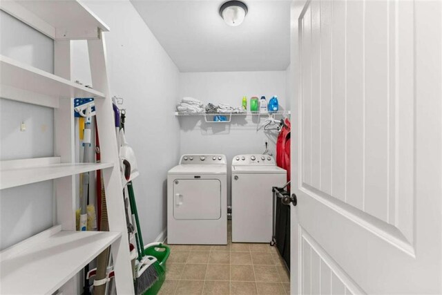 laundry room featuring washer and clothes dryer and light tile patterned flooring