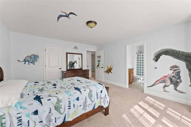 bedroom featuring light carpet and ensuite bath