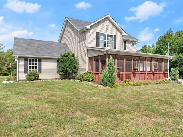 rear view of property with a sunroom and a yard