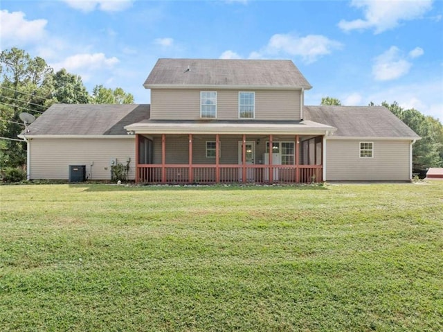 rear view of property with a yard, a sunroom, and central air condition unit