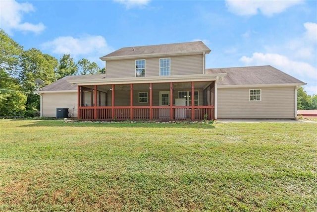 back of property with a sunroom, a yard, and cooling unit