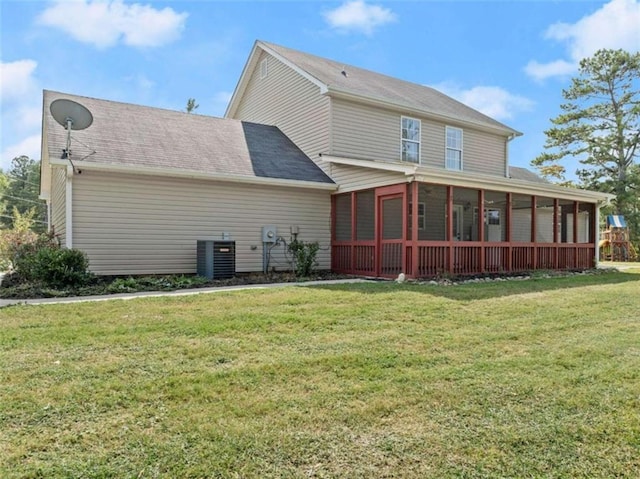 rear view of house featuring central AC, a sunroom, and a lawn