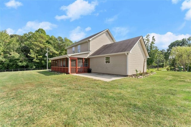 back of property featuring a patio area, a sunroom, and a lawn