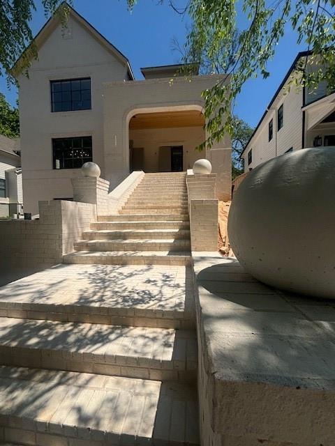 view of front of property featuring stucco siding and stairway