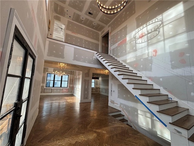 stairway featuring a high ceiling and a notable chandelier