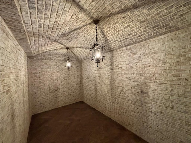 interior space with brick ceiling, brick wall, and vaulted ceiling