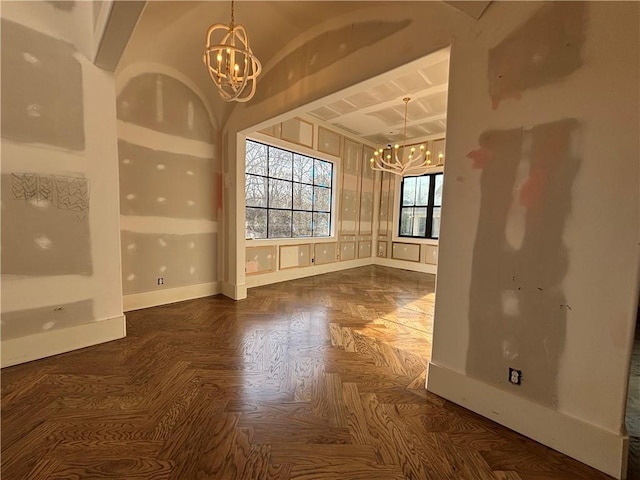 empty room featuring baseboards and a notable chandelier