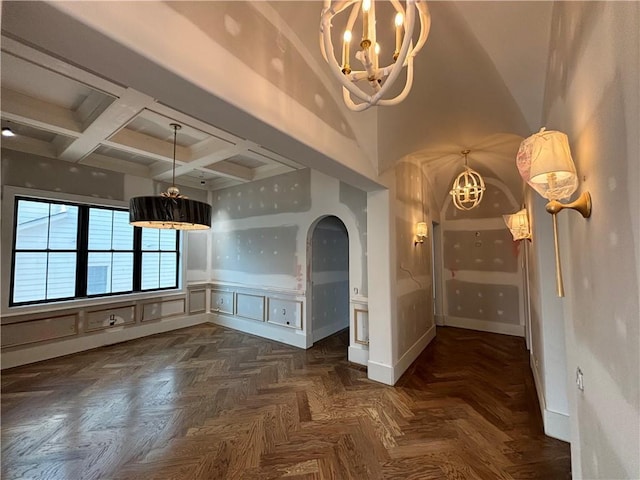 interior space with arched walkways, beamed ceiling, coffered ceiling, and a notable chandelier