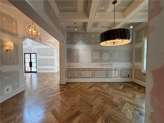 interior space with coffered ceiling, beamed ceiling, a notable chandelier, and baseboards