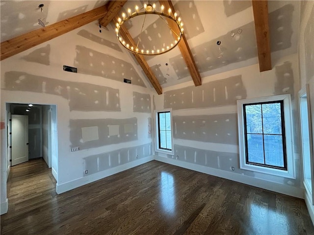 interior space featuring baseboards, wood finished floors, an inviting chandelier, high vaulted ceiling, and beam ceiling