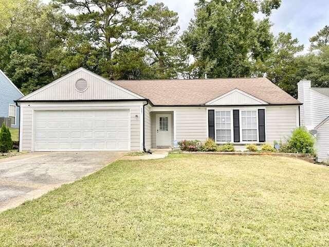 single story home with a front lawn and a garage