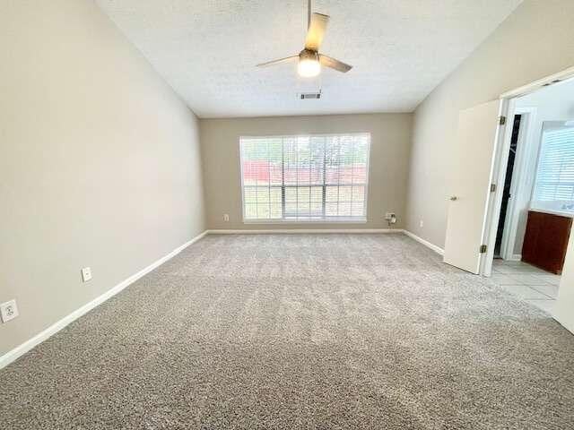 carpeted empty room featuring ceiling fan and a textured ceiling