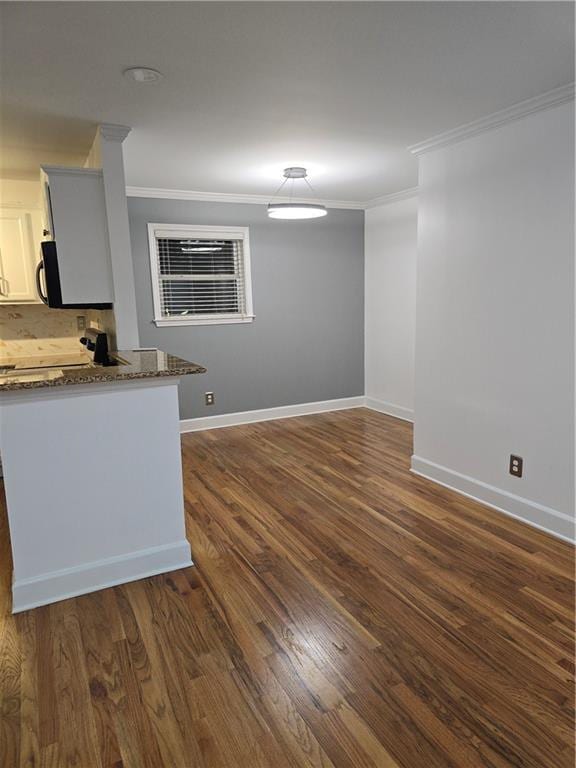 48 Peachtree Ave NE Unit 321, Atlanta, GA 30305 - kitchen featuring ornamental molding, dark stone counters, black microwave, dark wood finished floors, and white cabinetry