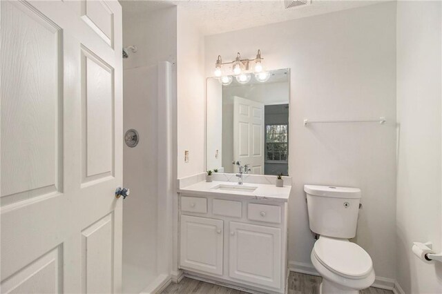 1025 Lakeside Cir, Covington, GA 30016 - full bath featuring a textured ceiling, walk in shower, baseboards, toilet, and vanity