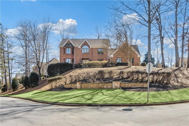 view of front of house with brick siding and a front lawn