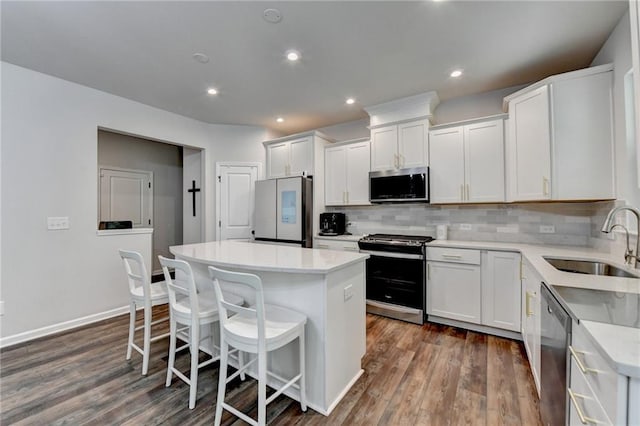 5215 Wheeler Run Dr, Auburn, GA 30011 - kitchen with appliances with stainless steel finishes, a sink, a kitchen island, a kitchen breakfast bar, and decorative backsplash