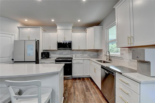5215 Wheeler Run Dr, Auburn, GA 30011 - kitchen with stainless steel appliances, a sink, dark wood-style floors, light stone counters, and white cabinetry
