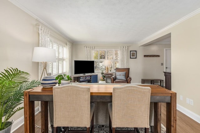 dining space with hardwood / wood-style flooring and crown molding