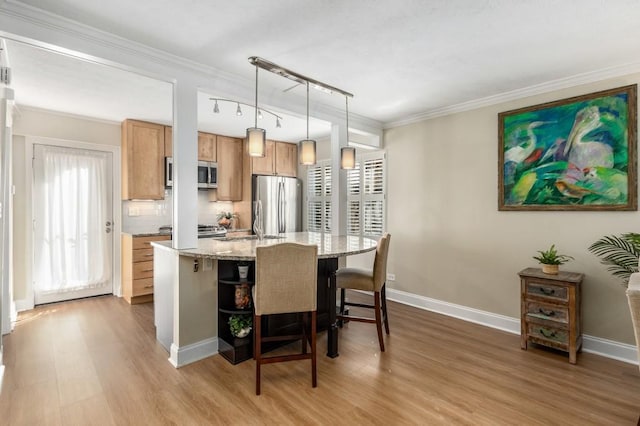 kitchen featuring a kitchen bar, decorative light fixtures, appliances with stainless steel finishes, an island with sink, and backsplash