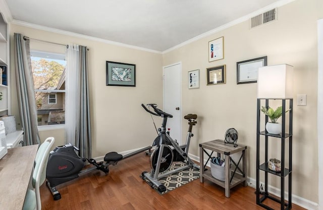 exercise room with wood-type flooring and ornamental molding