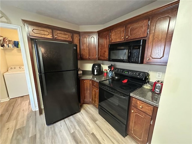 kitchen featuring washer / dryer, light hardwood / wood-style flooring, and black appliances