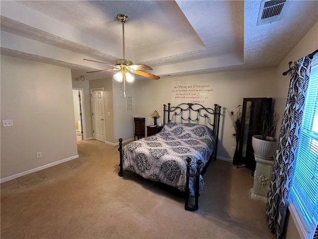 bedroom with a tray ceiling, ceiling fan, light colored carpet, and a textured ceiling