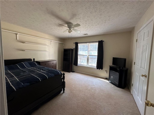 carpeted bedroom with ceiling fan and a textured ceiling