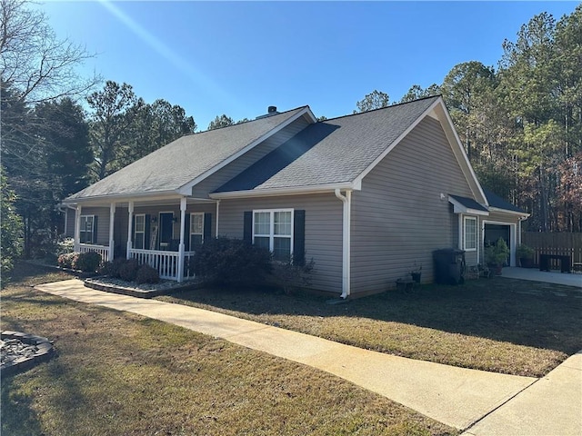 view of front of house with a front yard, a porch, and a garage