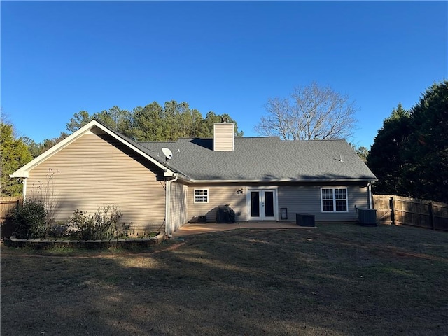 back of house featuring french doors, a yard, and cooling unit