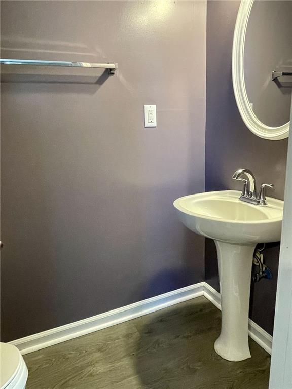 bathroom featuring baseboards, toilet, and wood finished floors