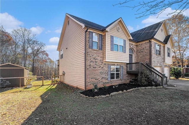 view of property exterior with a garage, driveway, brick siding, and fence