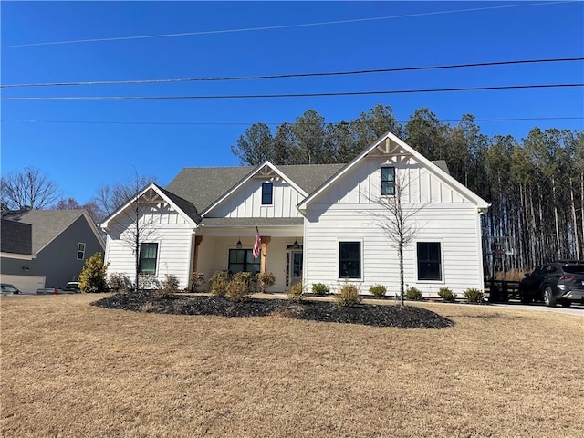 modern farmhouse featuring a front lawn, covered porch, and board and batten siding