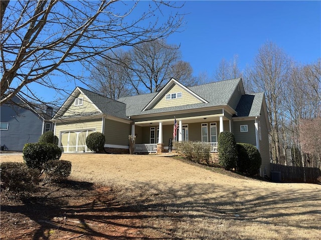 craftsman-style home with a garage, a porch, and roof with shingles