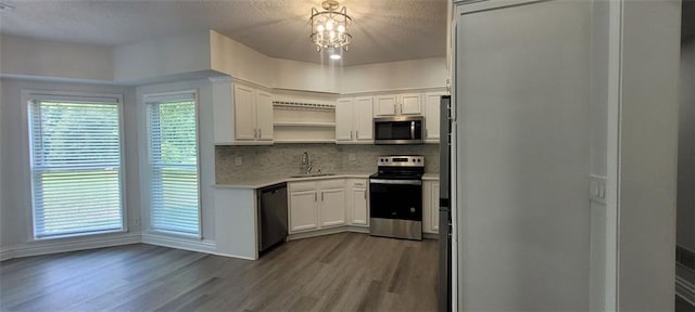 5690 Rutland Trce, Lithonia, GA 30058 - kitchen with stainless steel appliances, open shelves, dark wood finished floors, a chandelier, and light countertops